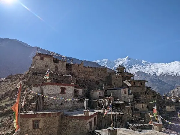 The stone houses and prayer flags of a Nar Phu village stacked against the hillside.