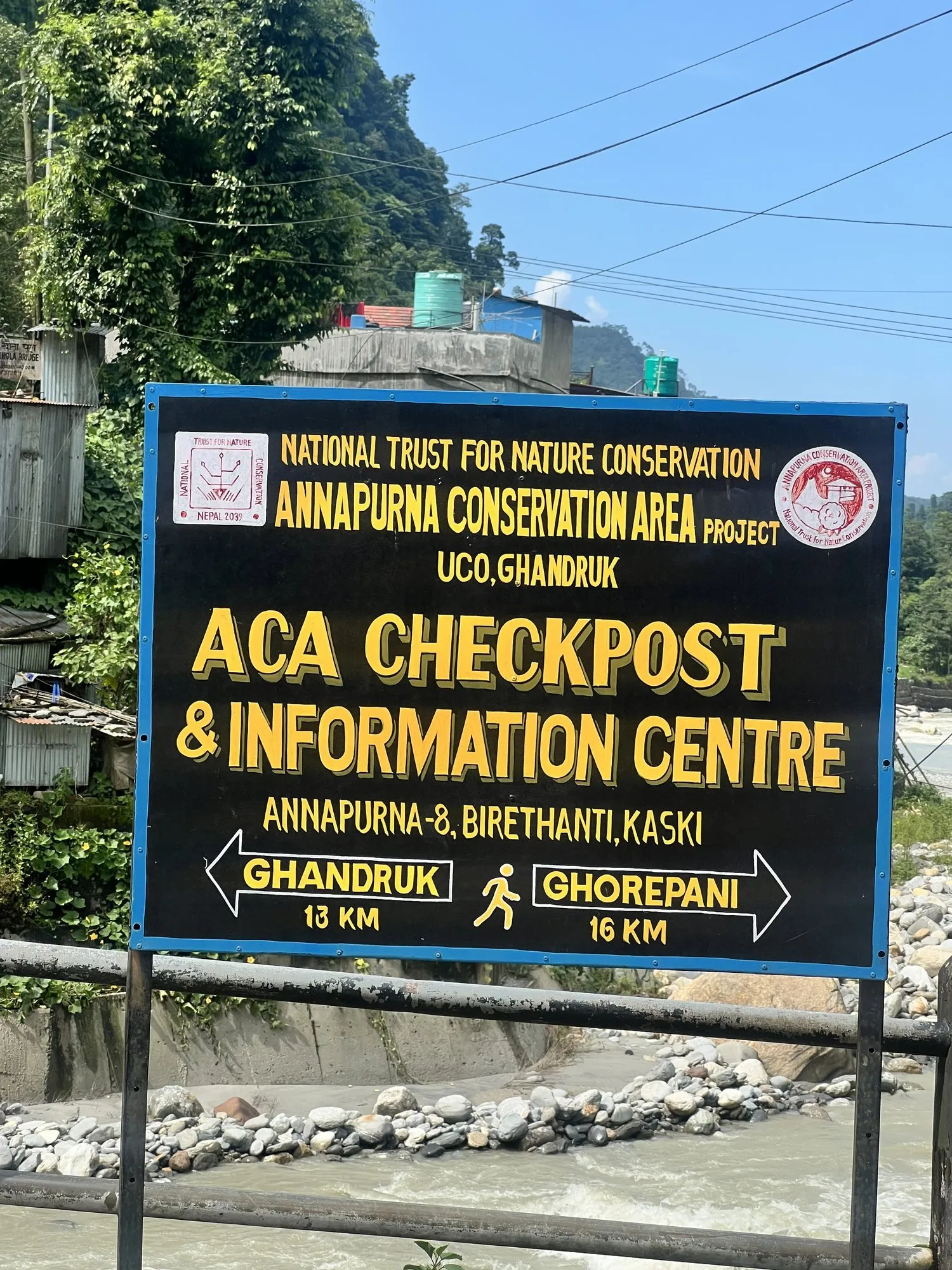 The Annapurna Conservation Area checkpost sign at Birethanti, pointing the way to Ghandruk and Ghorepani.